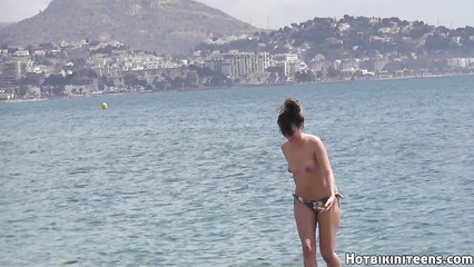 Откровенная девка разгуливает по общественному пляжу без лифчика